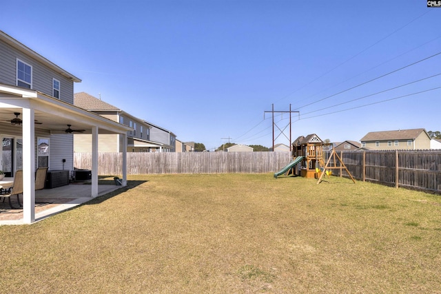 view of yard featuring a fenced backyard, ceiling fan, a playground, and a patio