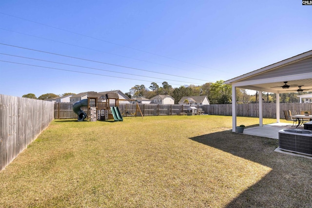 view of yard with central air condition unit, a patio area, a fenced backyard, and a playground