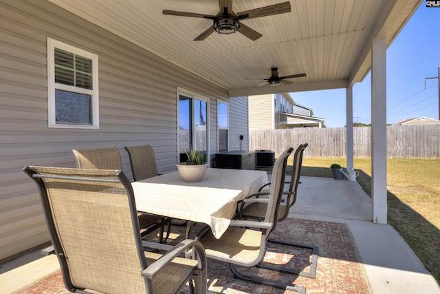 view of patio featuring a ceiling fan, outdoor dining space, and fence