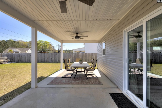 view of patio with fence, a ceiling fan, and outdoor dining space