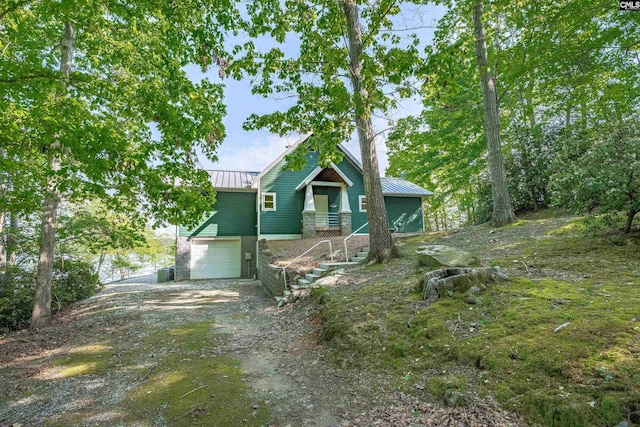 1724 Gold Nugget Pt, Prosperity, SC 29127 - view of front of home with a standing seam roof, dirt driveway, stairway, metal roof, and a garage