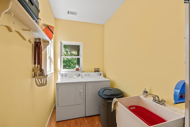 1724 Gold Nugget Pt, Prosperity, SC 29127 - laundry area featuring visible vents, a sink, laundry area, light wood-style flooring, and washing machine and dryer