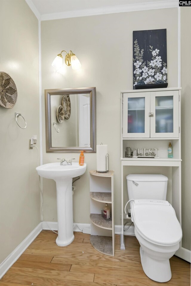 304 Oakhurst Pl, Blythewood, SC 29016 - half bathroom with baseboards, ornamental molding, toilet, and wood finished floors