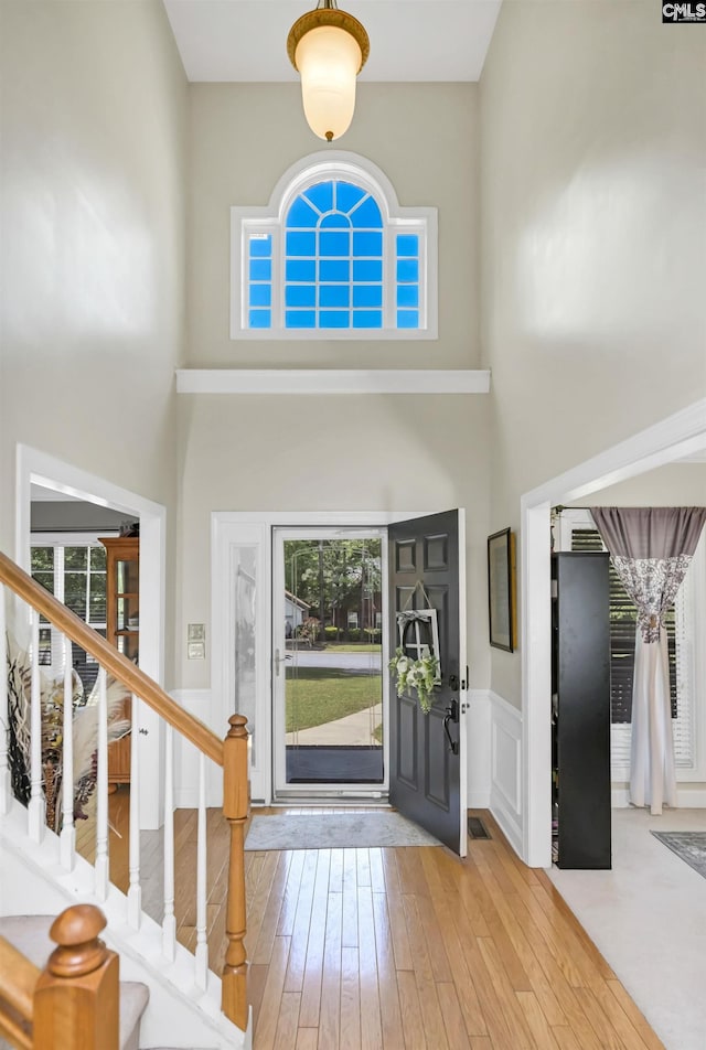 304 Oakhurst Pl, Blythewood, SC 29016 - foyer with wainscoting, a towering ceiling, stairs, and hardwood / wood-style flooring