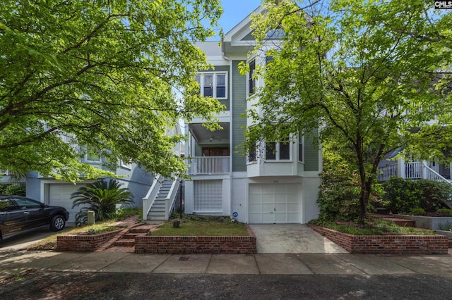 view of front facade with concrete driveway, stairway, stucco siding, and a garage