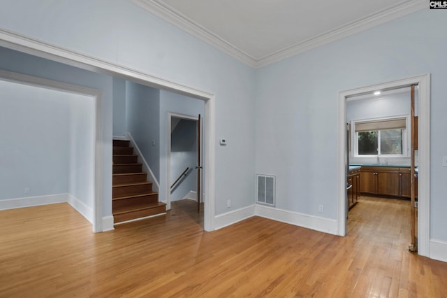 unfurnished room with baseboards, light wood-style flooring, crown molding, stairs, and visible vents