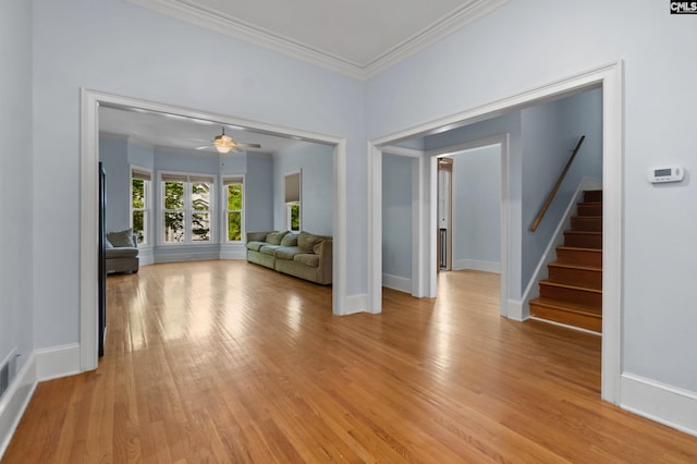 unfurnished living room featuring stairs, light wood-style floors, ornamental molding, and a ceiling fan