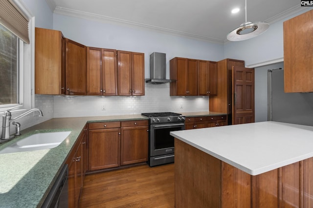 kitchen featuring decorative backsplash, stainless steel range with gas cooktop, a sink, and wall chimney range hood