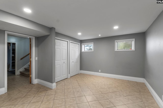 basement featuring recessed lighting, stairway, baseboards, and light tile patterned flooring