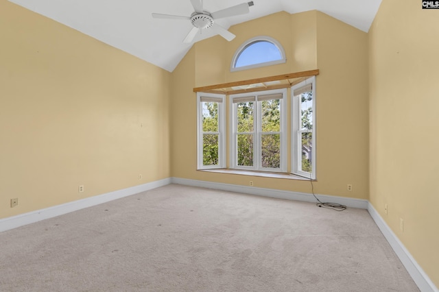 carpeted empty room featuring high vaulted ceiling, baseboards, and a ceiling fan