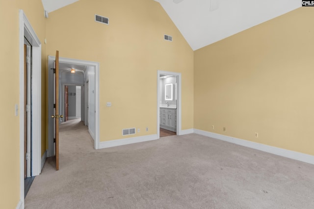 unfurnished bedroom with high vaulted ceiling, light colored carpet, and visible vents