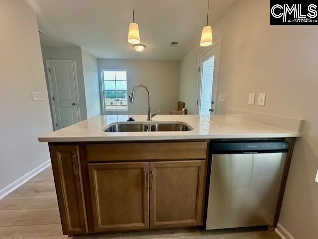 2022 Skyline Rd, Columbia, SC 29229 - kitchen featuring stainless steel dishwasher, a sink, baseboards, light countertops, and decorative light fixtures