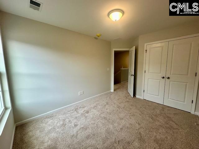 2022 Skyline Rd, Columbia, SC 29229 - unfurnished bedroom featuring light colored carpet, baseboards, and a closet