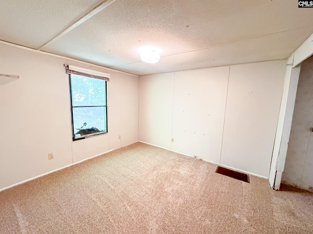 carpeted spare room featuring a textured ceiling