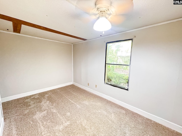 carpeted empty room with ornamental molding, baseboards, and a ceiling fan