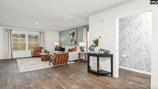 living area featuring recessed lighting, dark wood-type flooring, visible vents, and baseboards
