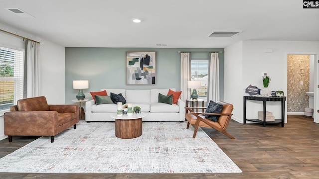 living area featuring wood finished floors, baseboards, and visible vents