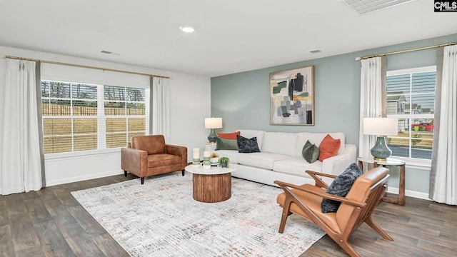 living room with visible vents, dark wood-style flooring, and baseboards