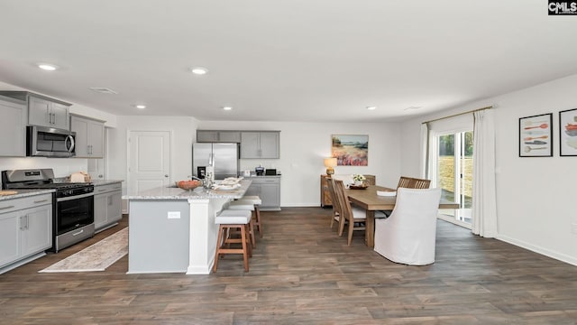 kitchen featuring dark wood-type flooring, gray cabinets, baseboards, and appliances with stainless steel finishes
