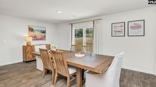 dining space with wood finished floors, baseboards, and visible vents
