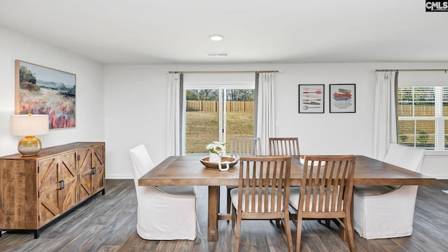 dining room featuring visible vents, dark wood finished floors, baseboards, and a healthy amount of sunlight