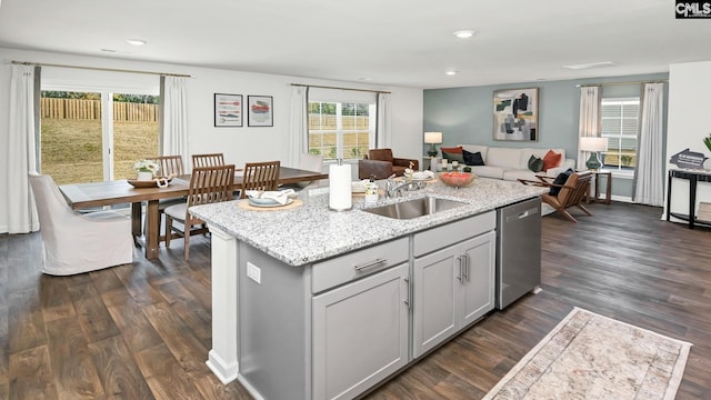 kitchen featuring a sink, open floor plan, a kitchen island with sink, dark wood finished floors, and stainless steel dishwasher