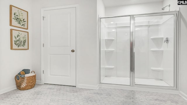 bathroom with a shower stall and baseboards