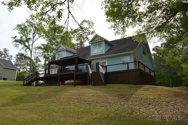 rear view of property with stairway, a wooden deck, and a lawn