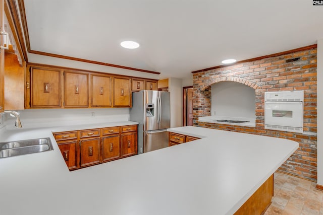 1605 Quail Lake Dr, West Columbia, SC 29169 - kitchen featuring a sink, light countertops, white appliances, a peninsula, and brown cabinets