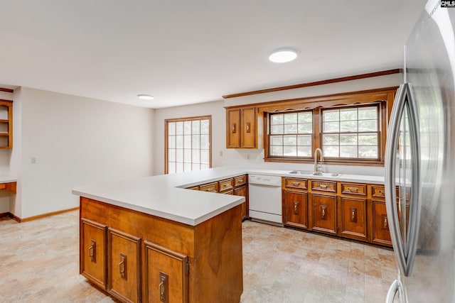 1605 Quail Lake Dr, West Columbia, SC 29169 - kitchen with light countertops, freestanding refrigerator, brown cabinets, dishwasher, and a sink