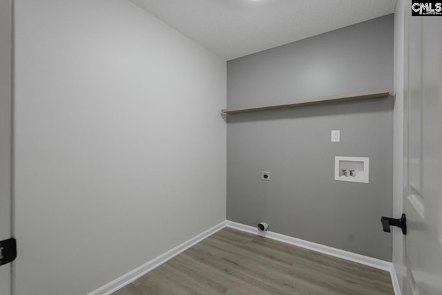 laundry area with laundry area, electric dryer hookup, wood finished floors, washer hookup, and baseboards
