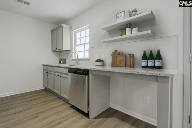 kitchen with light wood-type flooring, gray cabinetry, visible vents, decorative backsplash, and dishwasher