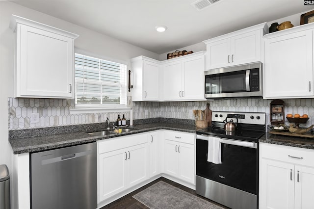 kitchen featuring tasteful backsplash, visible vents, white cabinets, a sink, and appliances with stainless steel finishes