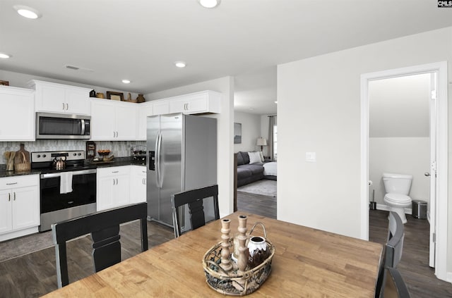kitchen with dark wood finished floors, white cabinets, and stainless steel appliances