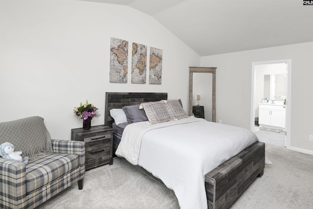 bedroom featuring light colored carpet, ensuite bathroom, and vaulted ceiling