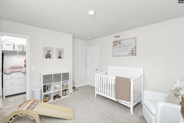 bedroom with a spacious closet, carpet flooring, and a closet