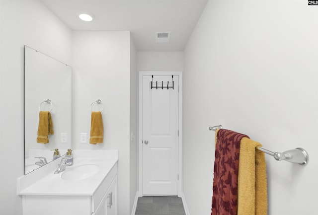 bathroom featuring visible vents, baseboards, and vanity