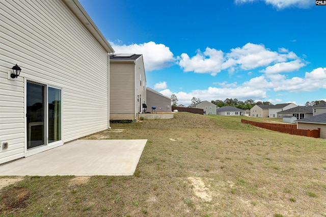 view of yard featuring a patio area, fence, and a residential view