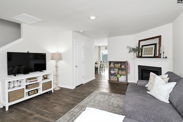 living area featuring baseboards, wood finished floors, and a fireplace