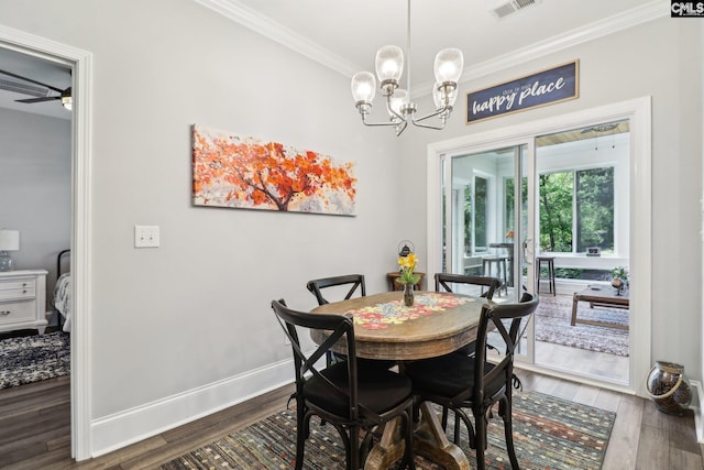dining room featuring a notable chandelier, dark wood-style floors, visible vents, and ornamental molding