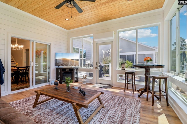 sunroom / solarium with crown molding, a wealth of natural light, wooden ceiling, and wood finished floors