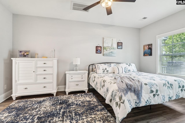 bedroom with dark wood-type flooring, visible vents, baseboards, and a ceiling fan