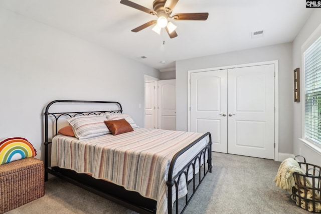 bedroom with visible vents, a closet, multiple windows, and light carpet