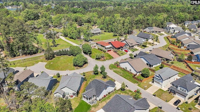 drone / aerial view with a wooded view and a residential view