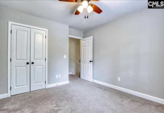 unfurnished bedroom with carpet floors, a closet, baseboards, and ceiling fan