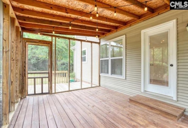 unfurnished sunroom with beam ceiling