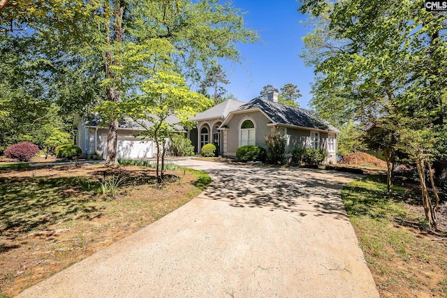 1168 Peninsula Dr, Prosperity, SC 29127 - view of front of home with a garage, stucco siding, a chimney, and concrete driveway