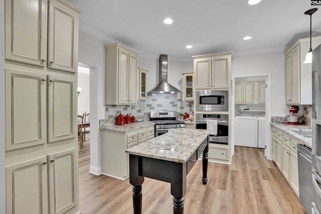 107 Turkey Ridge Ln, Lugoff, SC 29078 - kitchen with cream cabinetry, stainless steel appliances, wall chimney range hood, light wood-style floors, and washer and dryer
