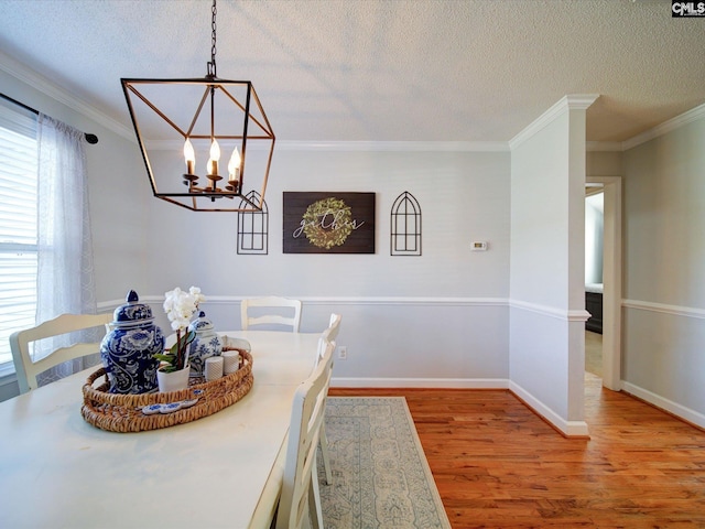 78 Southern Oak Dr, Camden, SC 29020 - dining space with a notable chandelier, a textured ceiling, light wood-style floors, and ornamental molding
