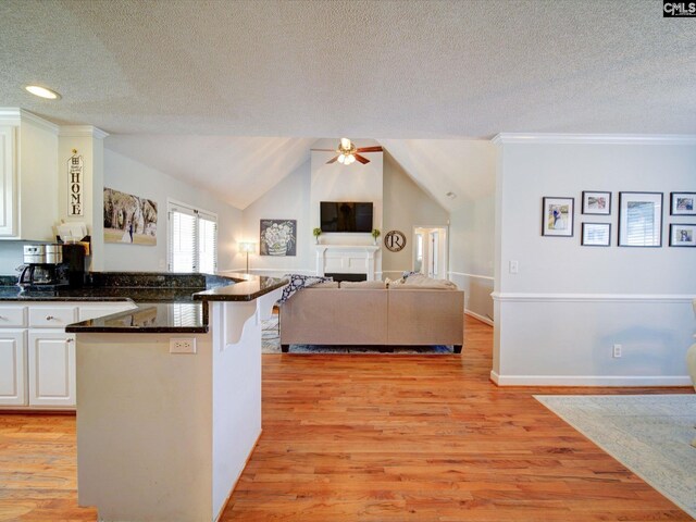 78 Southern Oak Dr, Camden, SC 29020 - kitchen featuring white cabinets, a peninsula, a textured ceiling, dark countertops, and a ceiling fan